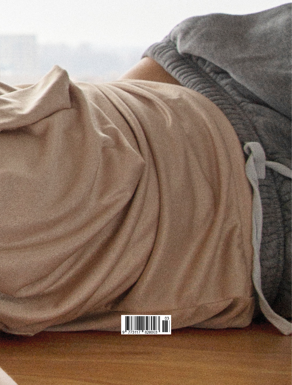 Concerning Magazine cover, close-up of a figure lying on a wooden floor, editorial design