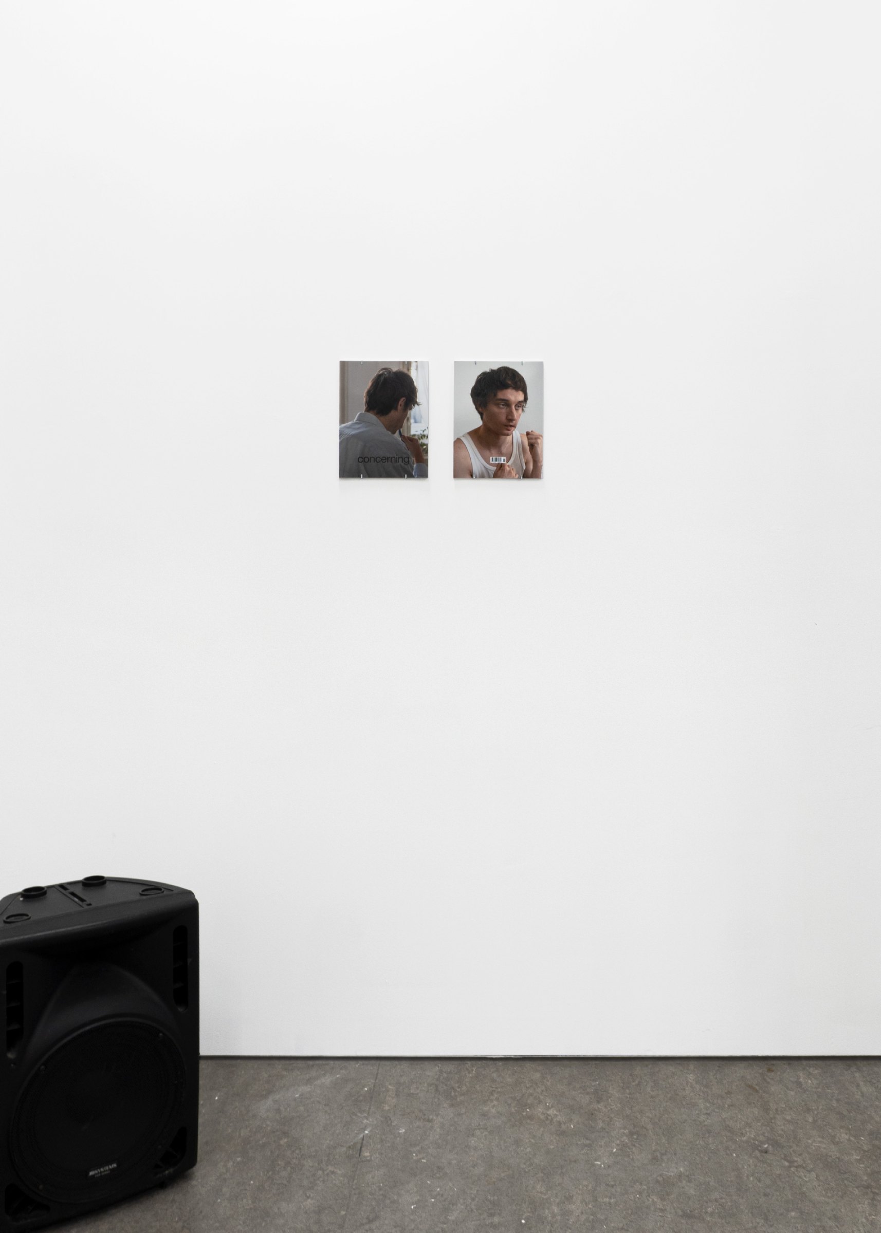 Two small portrait photographs on a white gallery wall, Concerning Magazine, Jonathan Issue